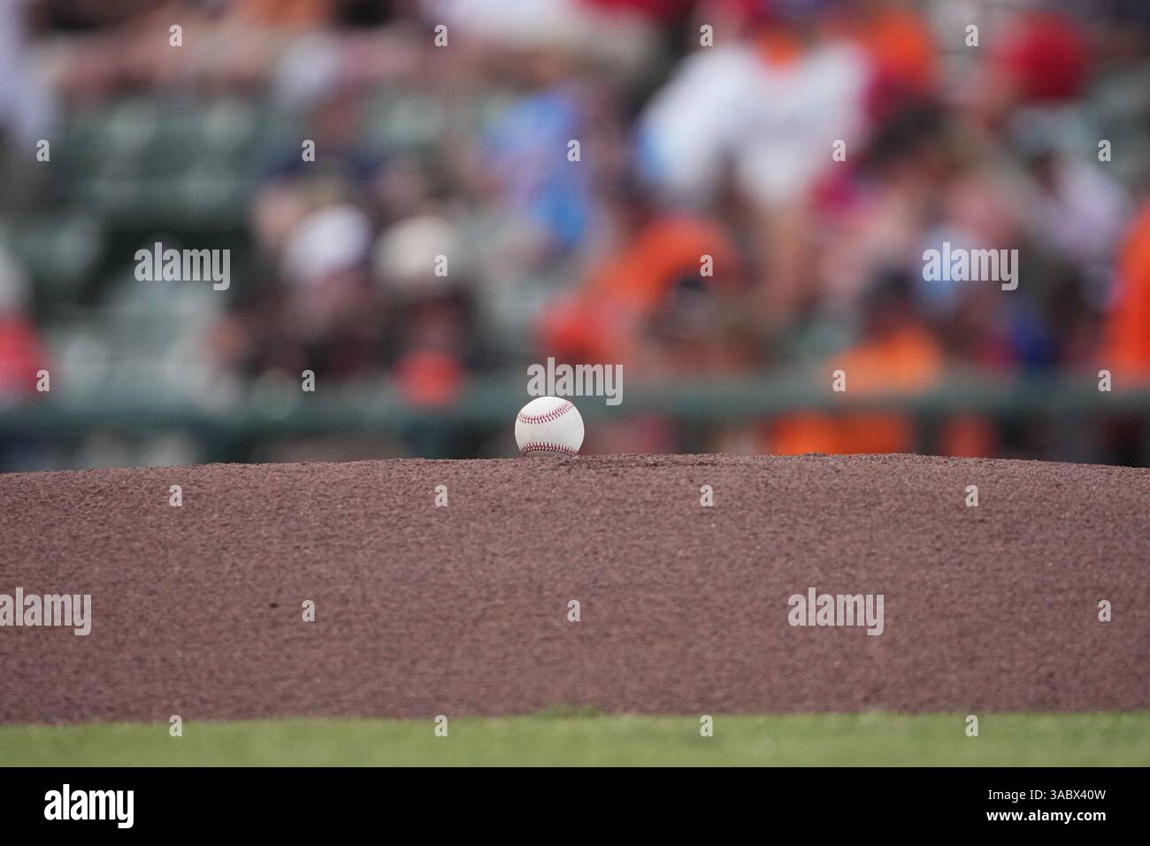 A baseball on the dirt of a pitching mound between innings of a ...
