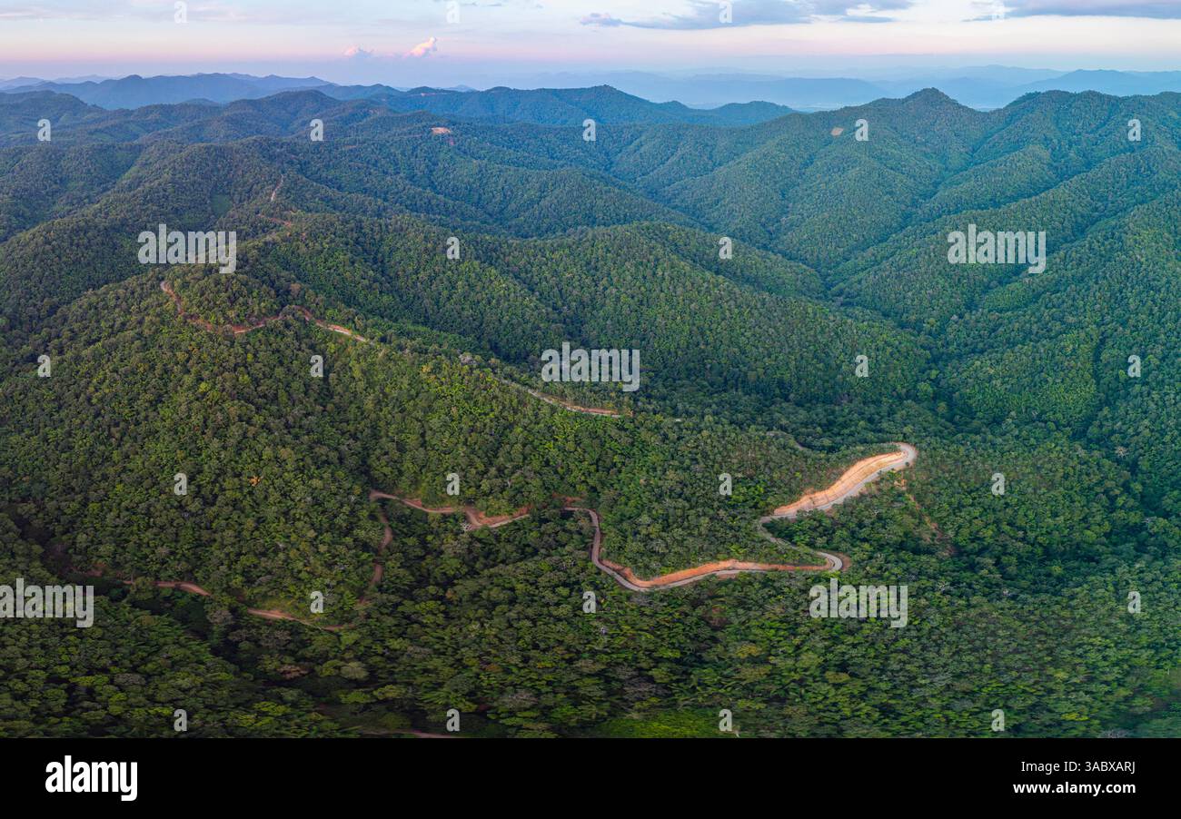 aerial view of a winding mountain road surrounded by lush greenery ...
