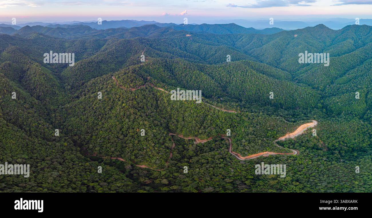aerial view of a winding mountain road surrounded by lush greenery ...