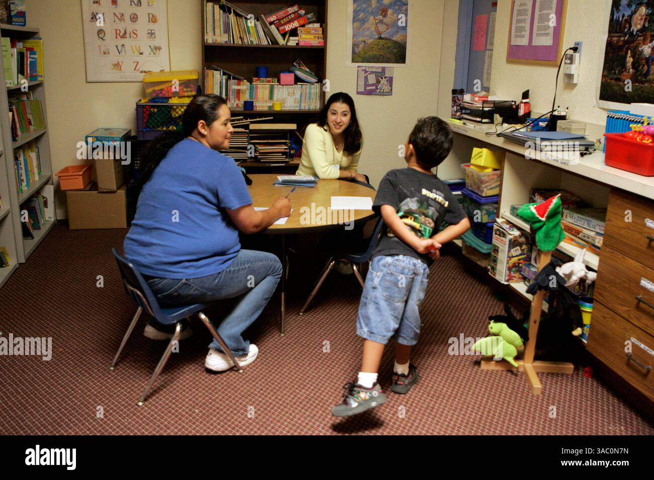 (Published 10/16/2005, E-5)  Lydia T. Contreras, developmental screening coordinator for Children's Care Connection (C3), a Children's Hospital Program, center, assesses Henry Roldan, 4, right, as his mother Herlinda Quintana, left, fills out paperwork at Mental Health Systems Family Recovery Center in Oceanside.--Laura Embry/Union-Tribune Stock Photo