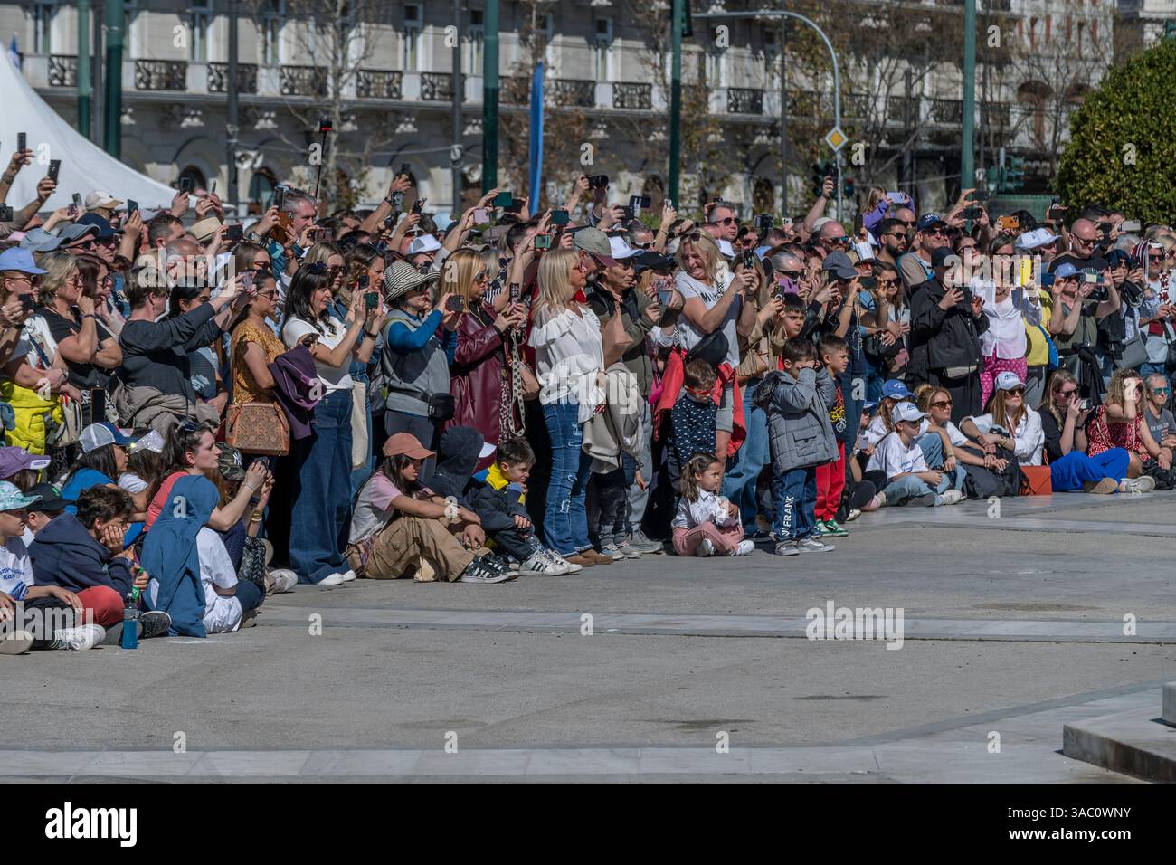 A crowd of people attend a public event holding smartphones to take pictures and videos Stock Photo