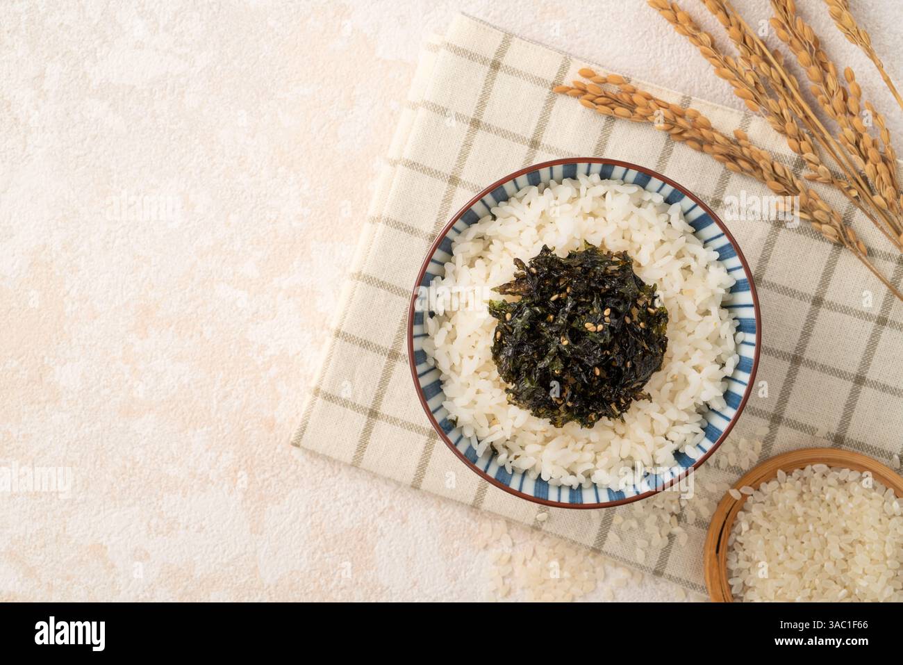 A bowl of fluffy white rice topped with seasoned seaweed and sesame ...