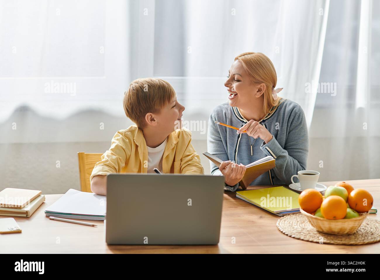 A mother guides her son through homework, cultivating knowledge and ...