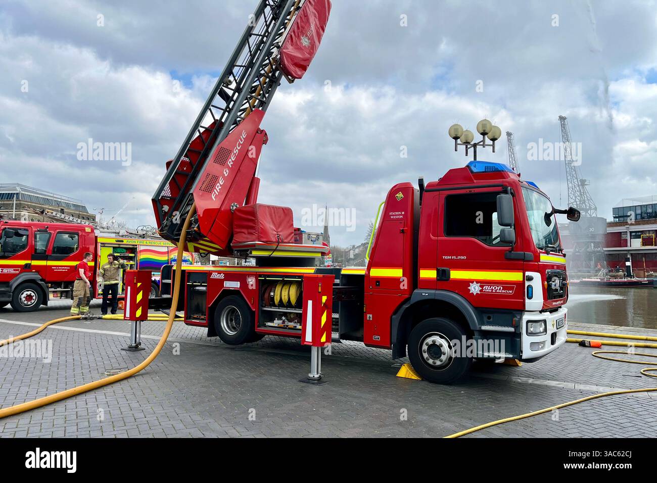 An Avon Fire & Rescue Fire Engine with ladder extended and stabilisers engaged on a routine training exercise near the Bristol Floating Harbour. - Smartphone Captured Stock Image
