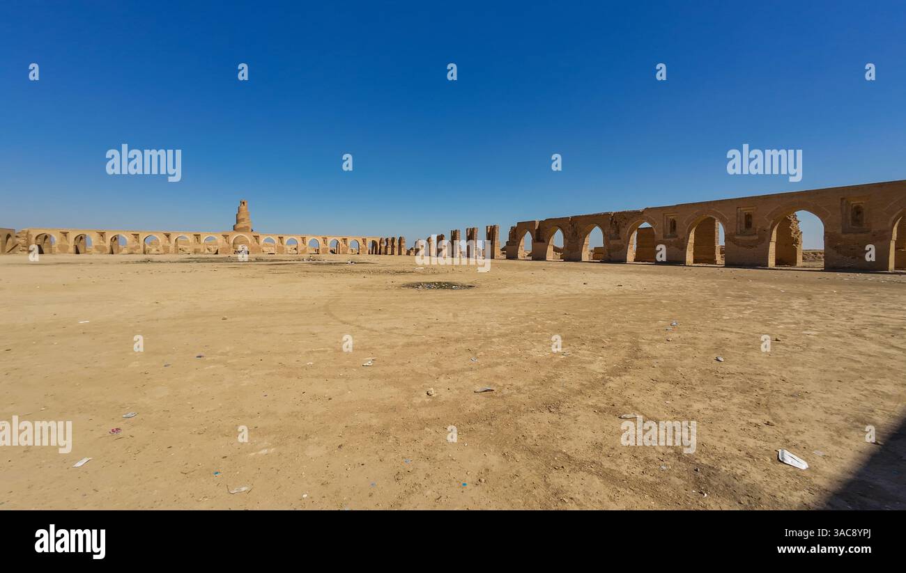 A vast desert landscape featuring ancient ruins with arches and a tall ...