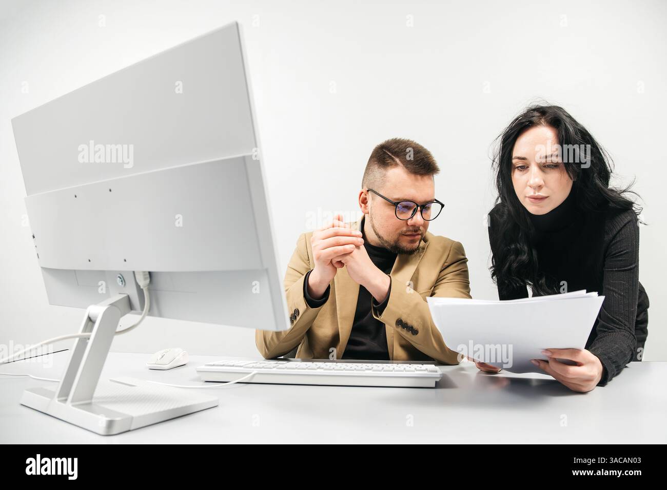 Two versatile business analysts discussing data management using a laptop. Concept consulting, training Stock Photo