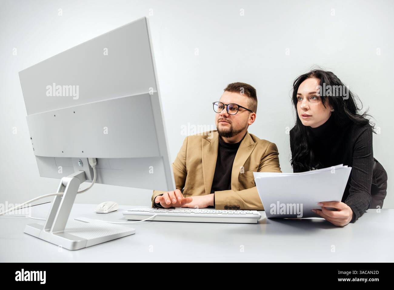 Two versatile business analysts discussing data management using a laptop. Concept consulting, training Stock Photo