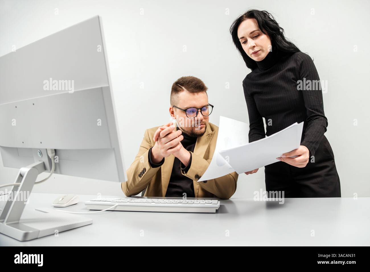 Two versatile business analysts discussing data management using a laptop. Concept consulting, training Stock Photo