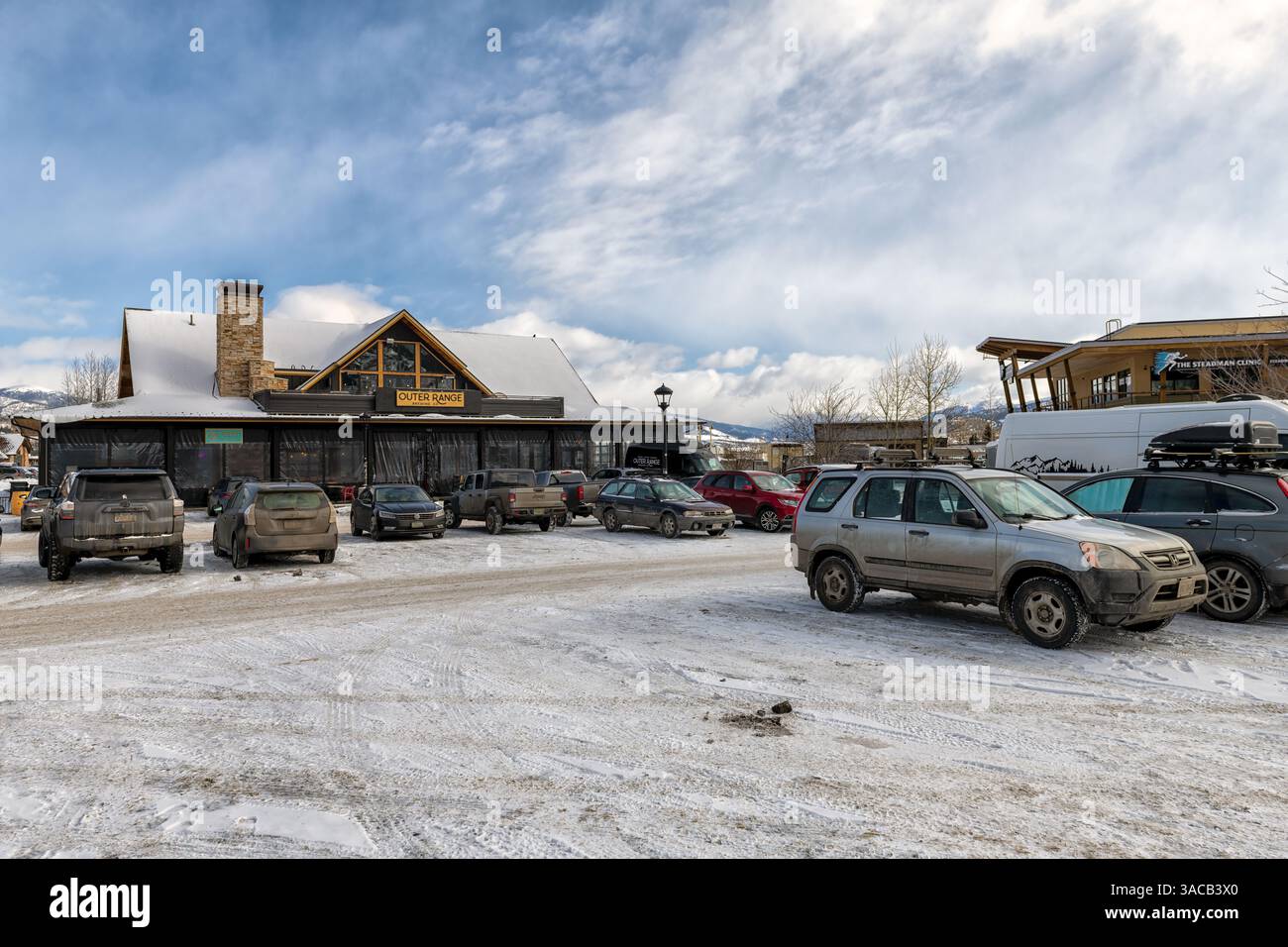 Frisco, USA - January 26, 2023: Colorado ski resort town street by parking lot on shopping strip mall, brewery restaurant store shop in winter snow Stock Photo