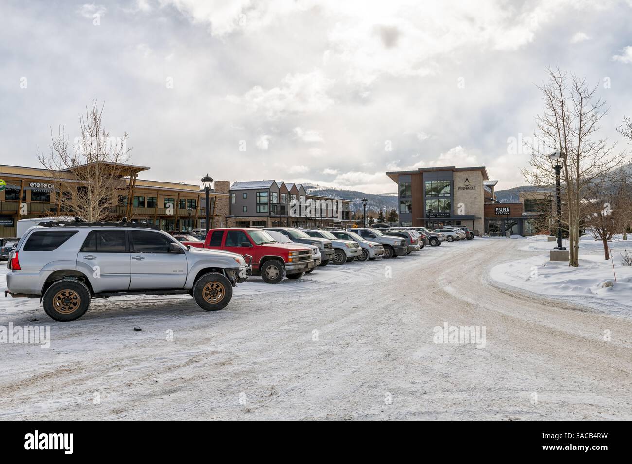 Frisco, USA - January 26, 2023: Colorado ski resort town street by parking lot on shopping strip mall with furniture store, eyeglasses shop Stock Photo