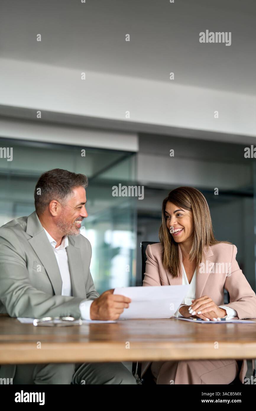 Two happy professional executives discussing financial documents in office. Stock Photo