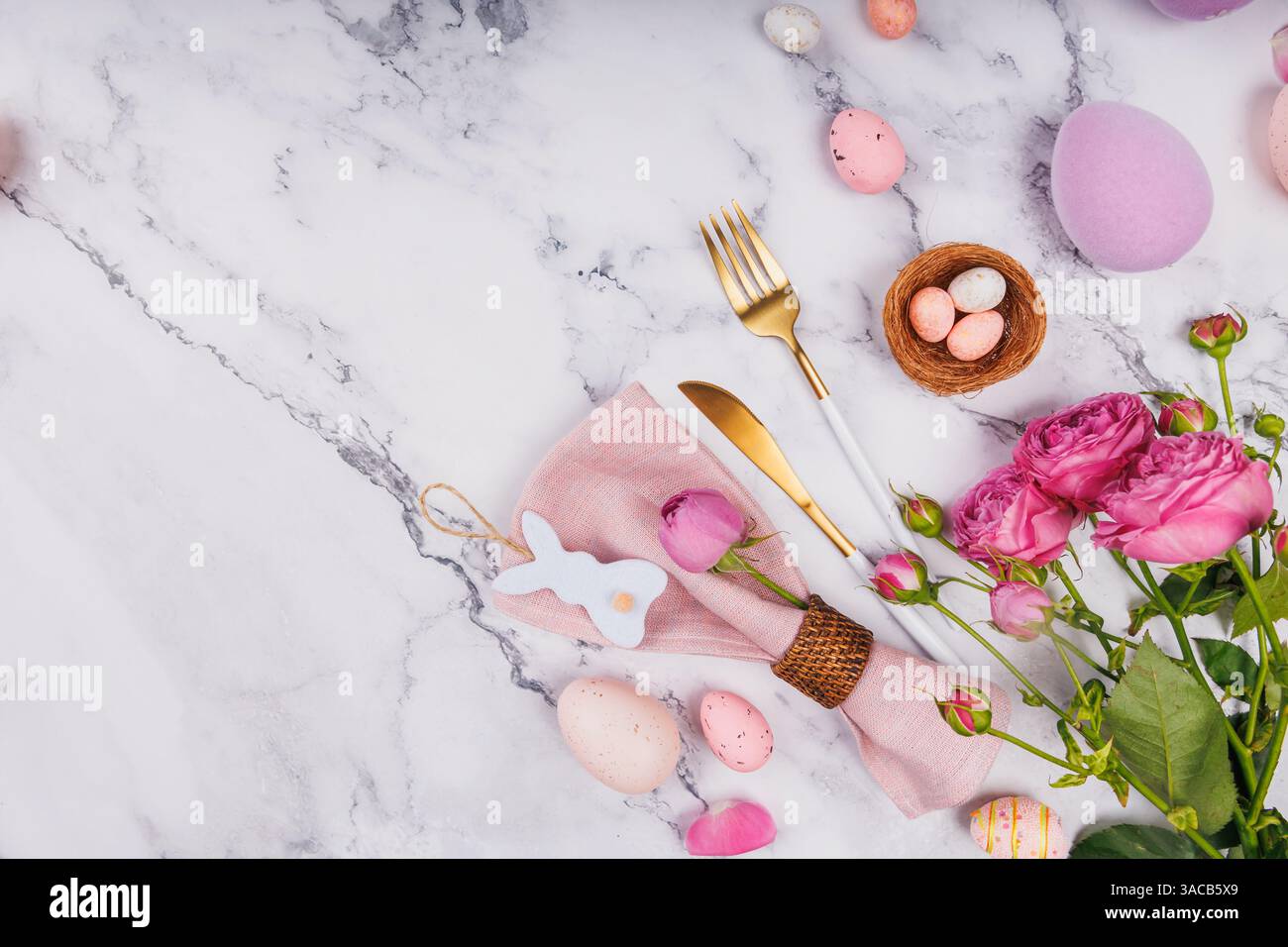Easter Table Setting with Roses and Gold Cutlery Stock Photo