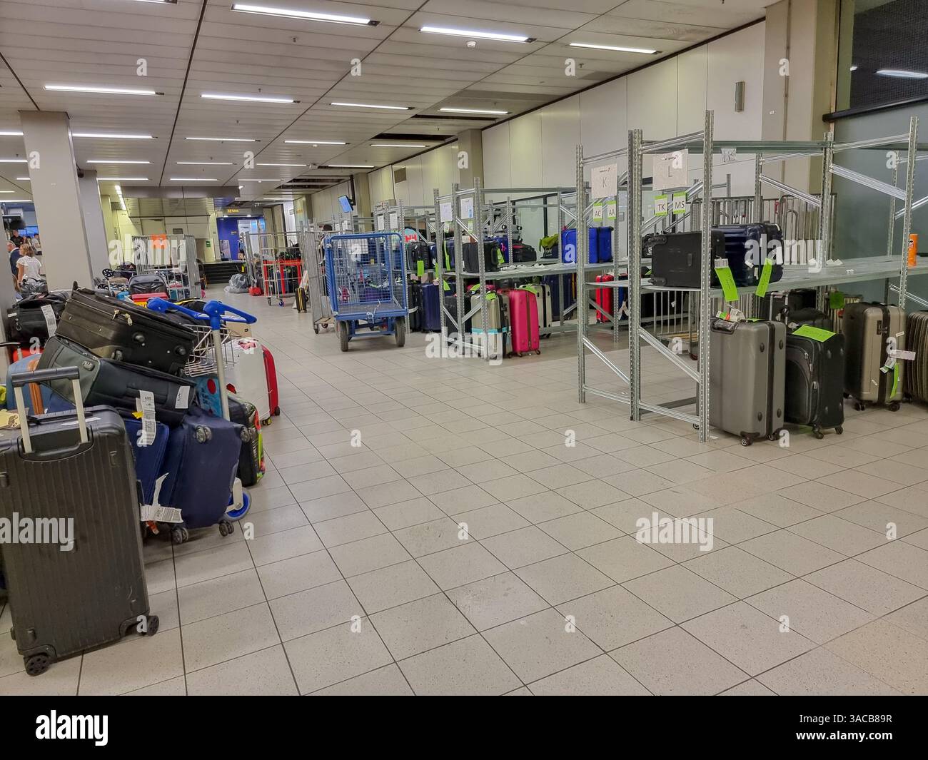 Piles of delayed baggage / lost luggage / suitcases in storage at Amsterdam Airport - Smartphone Captured Stock Image