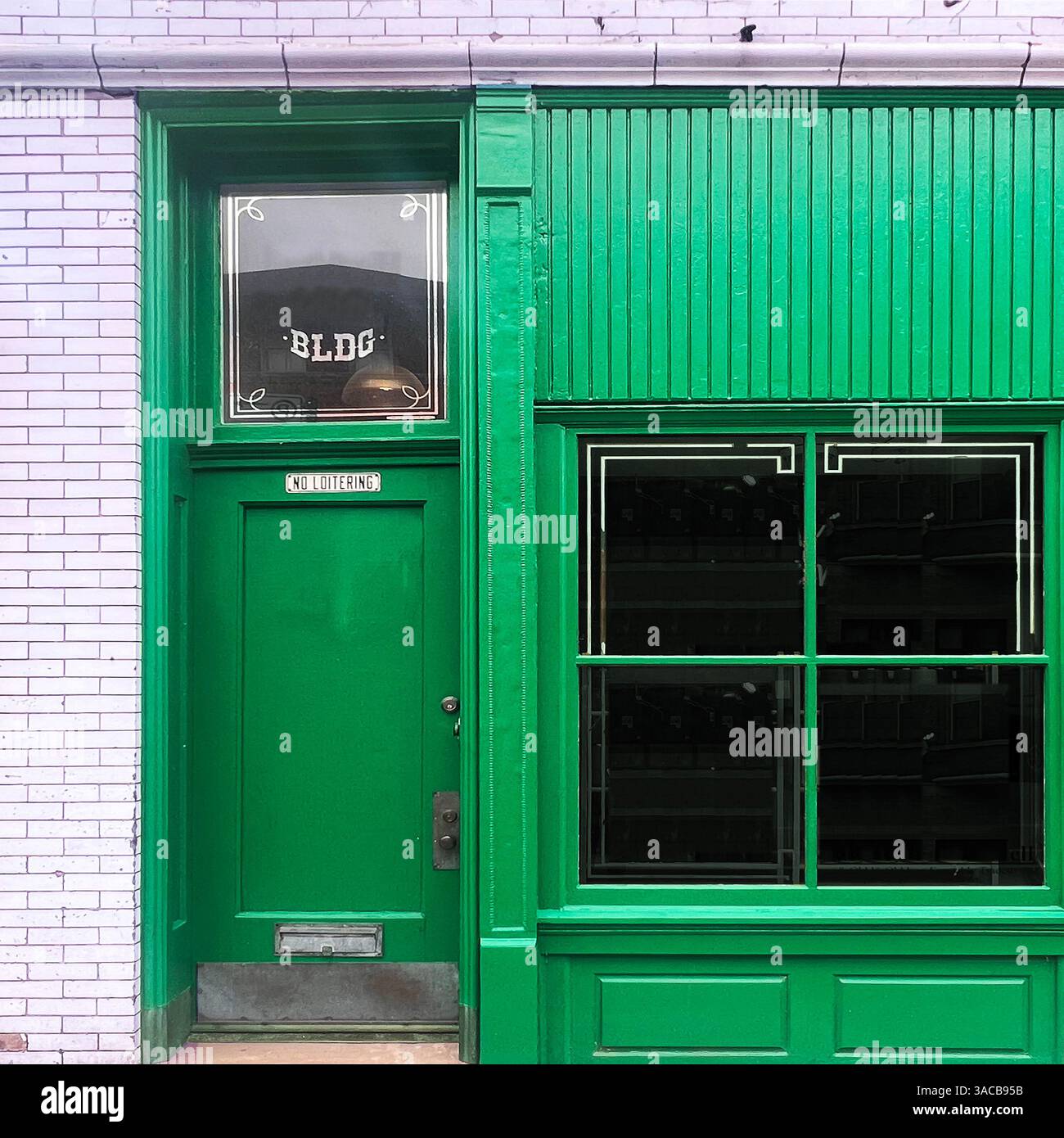 A vibrant green storefront with vintage signage against a white tile wall, showcasing classic Chicago street style - Smartphone Captured Stock Image