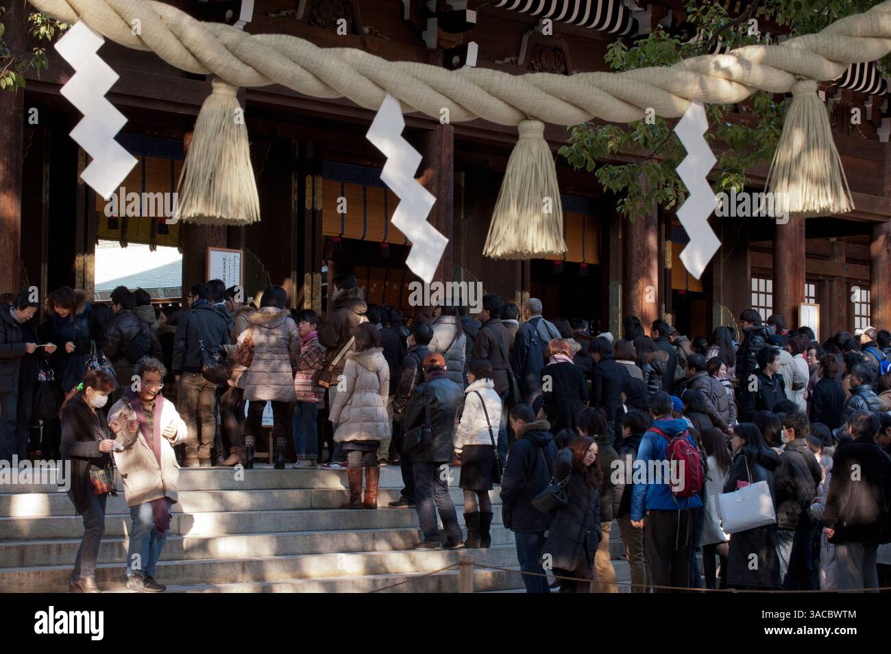 Shimenawa (twisted sacred straw rope) and shide (zigzag white paper strips) indicates the presence of kami (Shinto deity) at Meiji Jingu, Tokyo, Japan. Stock Photo