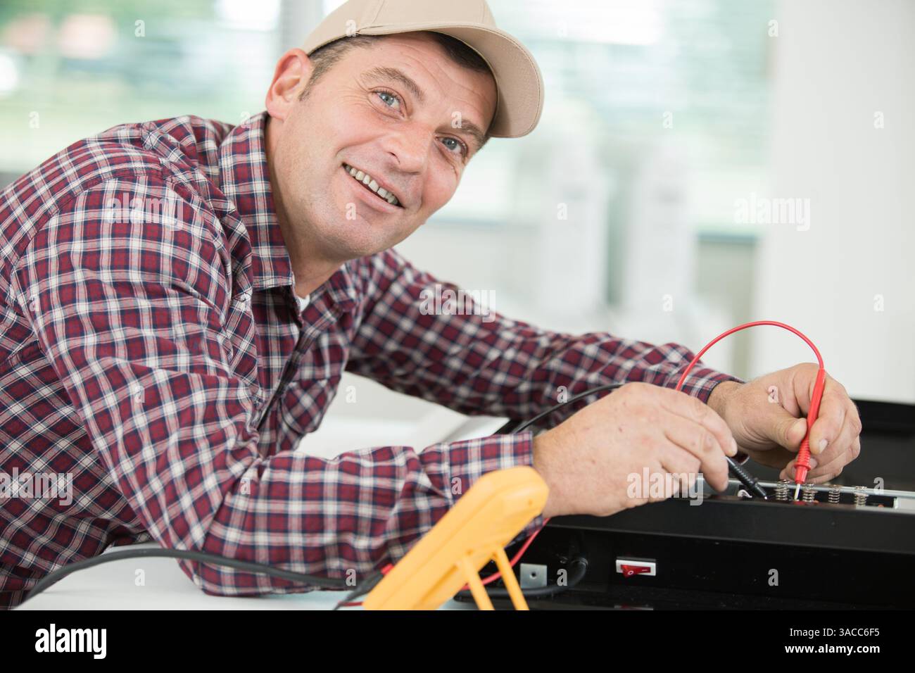 happy technician man using screwdriver and digital multimeter Stock Photo