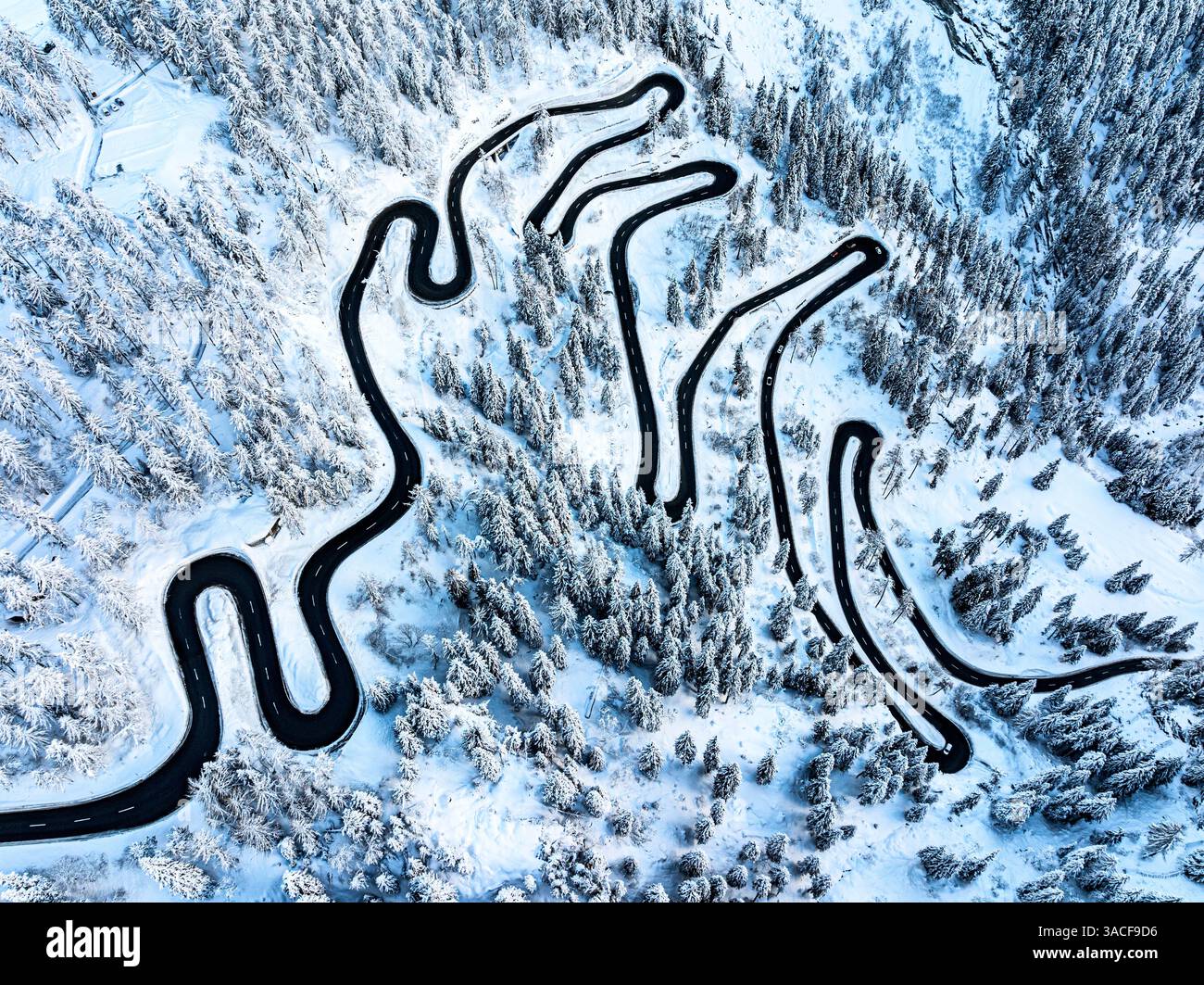Aerial view of a winding mountain road in the snowy woods Stock Photo ...