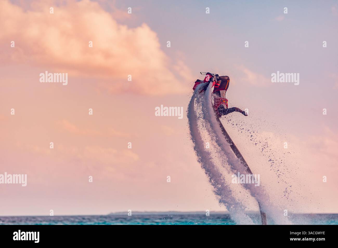 Flyboard Rider Silhouette of a fly board rider at sea. Professional rider do tricks in ...