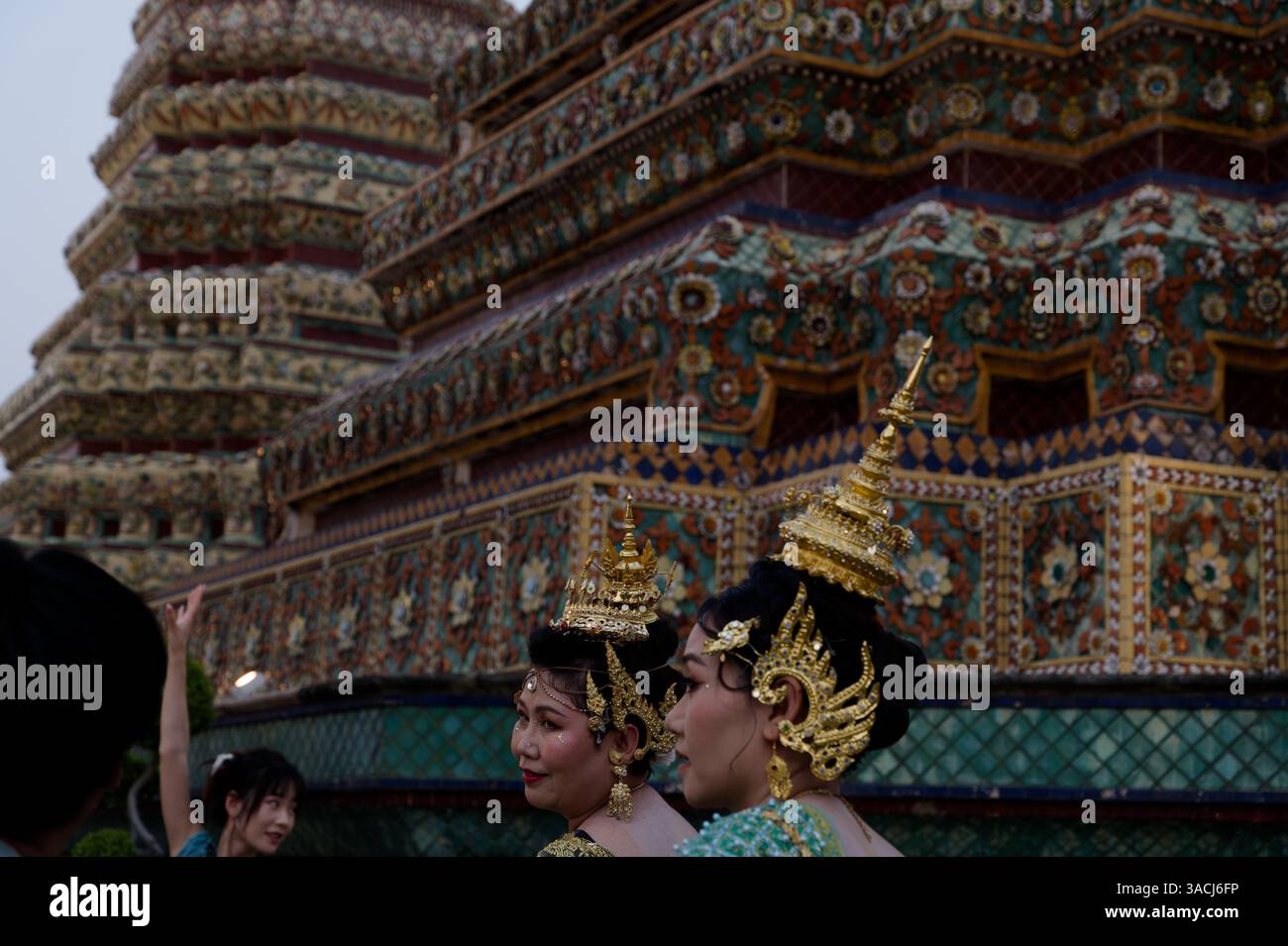 Two women dressed in traditional Thai attire visiting Wat Pho temple Stock Photo
