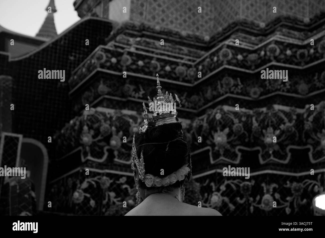 Woman with traditional Thai hair piece beneath the ornate stupas of Wat Pho Stock Photo