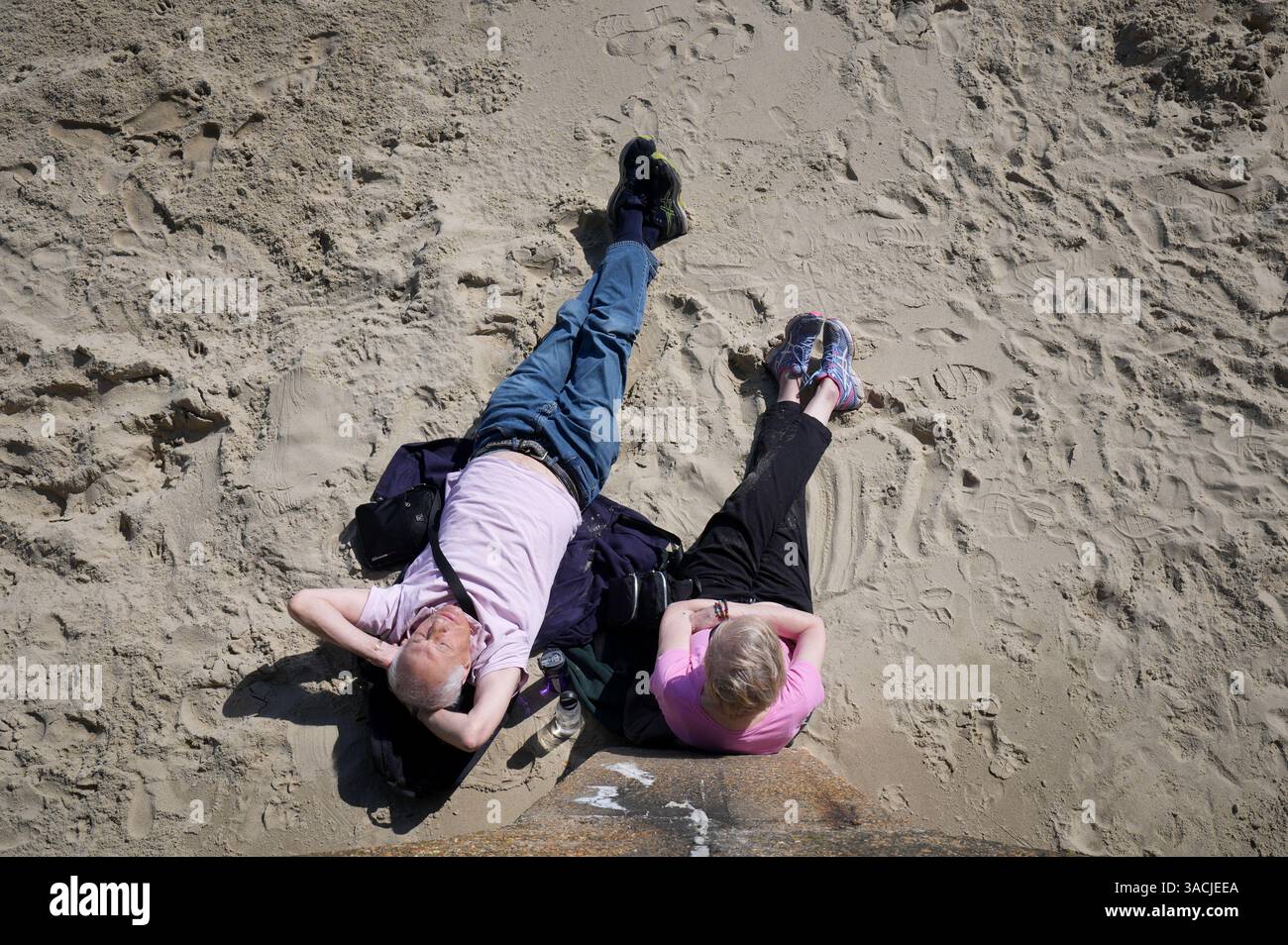 a-couple-enjoy-the-sunshine-on-the-beach-in-folkestone-kent-the-uk