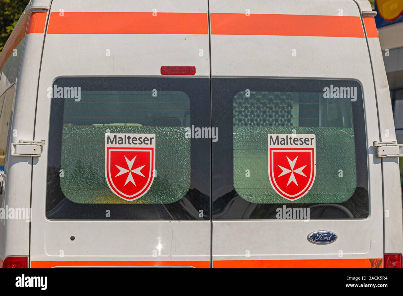 Belgrade, Serbia - August 31, 2024: Malteser Cross Sign Coat of Arms at Ambulance Vehicle Ems Malta. Stock Photo