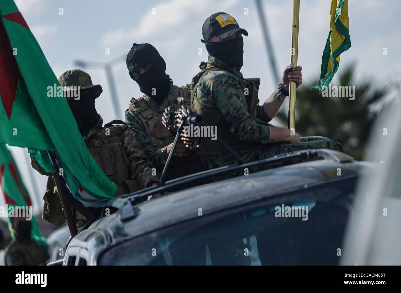 U.S.-backed Kurdish fighters stand on their vehicles, as they withdraw ...