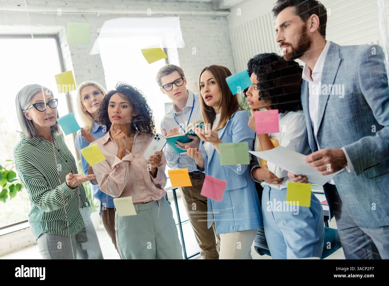 Diverse team collaborating on a creative project in a bright office space Stock Photo