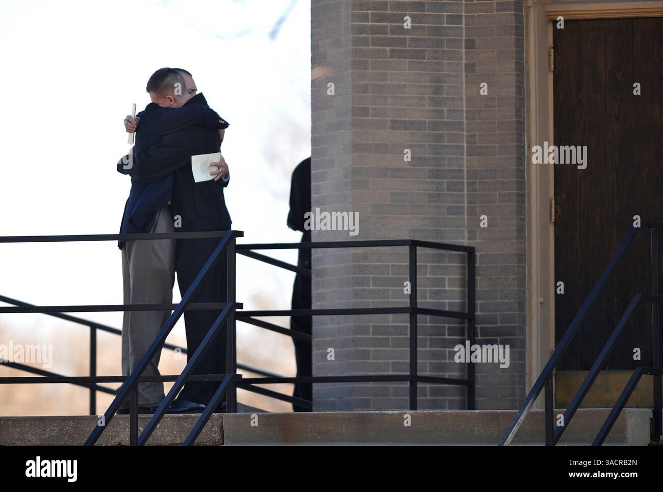 Dec. 05, 2009 - Burlingame, Kansas, U.S. - Following a memorial service held for Karen, Emily, and Lauren Kahler, two memorial service attendees console each other outside The Federated Church in town.  The service was held just blocks away from the house where the three lost their lives when James Kraig Kahler allegedly shot and killed them one week earlier. (Names were not able to be obtained because photographers were not allowed on church property). (Credit Image: &#169; John Schreiber/ZUMAPRESS.com) Stock Photo