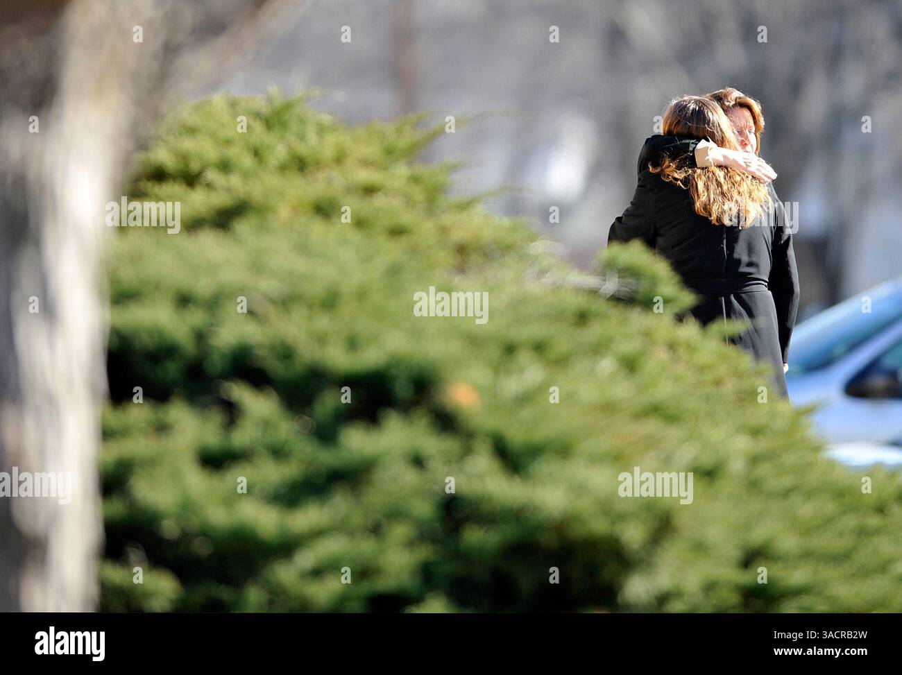 Dec. 05, 2009 - Burlingame, Kansas, U.S. - Following a memorial service held for Karen, Emily, and Lauren Kahler, two memorial service attendees console each other outside The Federated Church in town.  The service was held just blocks away from the house where the three lost their lives when James Kraig Kahler allegedly shot and killed them one week earlier. (Names were not able to be obtained because photographers were not allowed on church property). (Credit Image: &#169; John Schreiber/ZUMAPRESS.com) Stock Photo