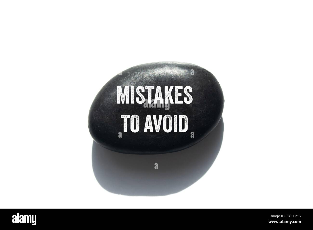 Mistakes to avoid message written on black stone on white background ...