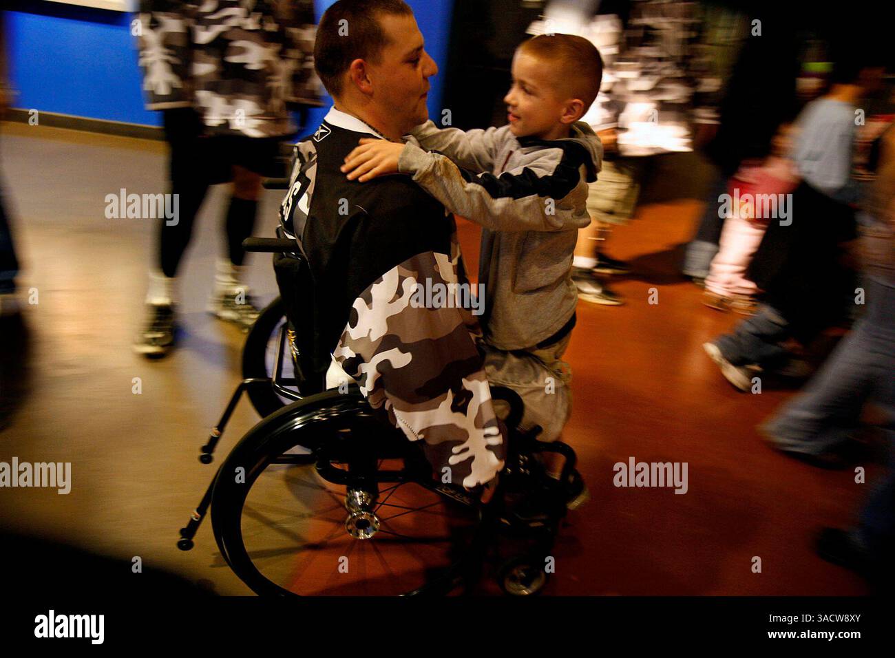 Feb 23, 2007 - San Antonio, Texas, USA - On September 5, 2006, Staff Sgt. DANIEL BARNES was on a night road clearance mission near Baghdad when a rocket-propelled grenade struck his Humvee. A few hours later, doctors at the 10th Combat Support Hospital in Baghdad amputated both of his legs and Daniel began his long journey home. Daniel's athleticism has carried him far but his above the knee amputations have made using prosthetics difficult. It has been a year and a half filled with small triumphs and frustrating setbacks. PICTURED: Staff Sgt. DANIEL BARNES gives his son TOBIAS BARNES, 7, a ri Stock Photo