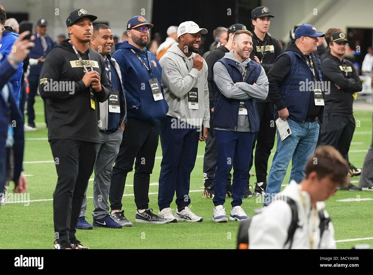 A brace of NFL scouts look on as players take part in passing drills ...