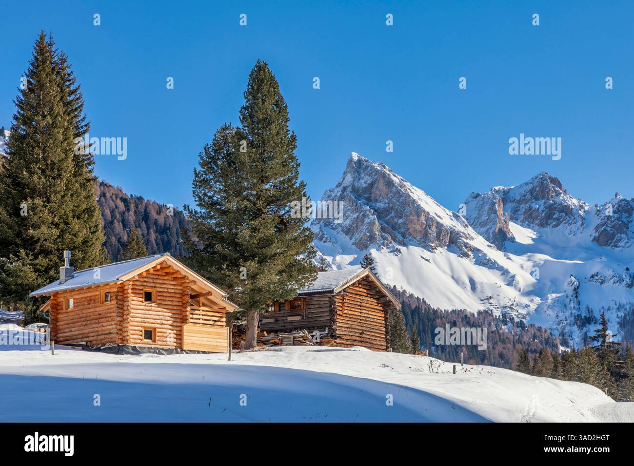lonely huts in san nicolo valley, winter landscape on a sunny day with snow and blue sky, pozza di fassa, autonomous province of trento, dolomites, italy Stock Photo