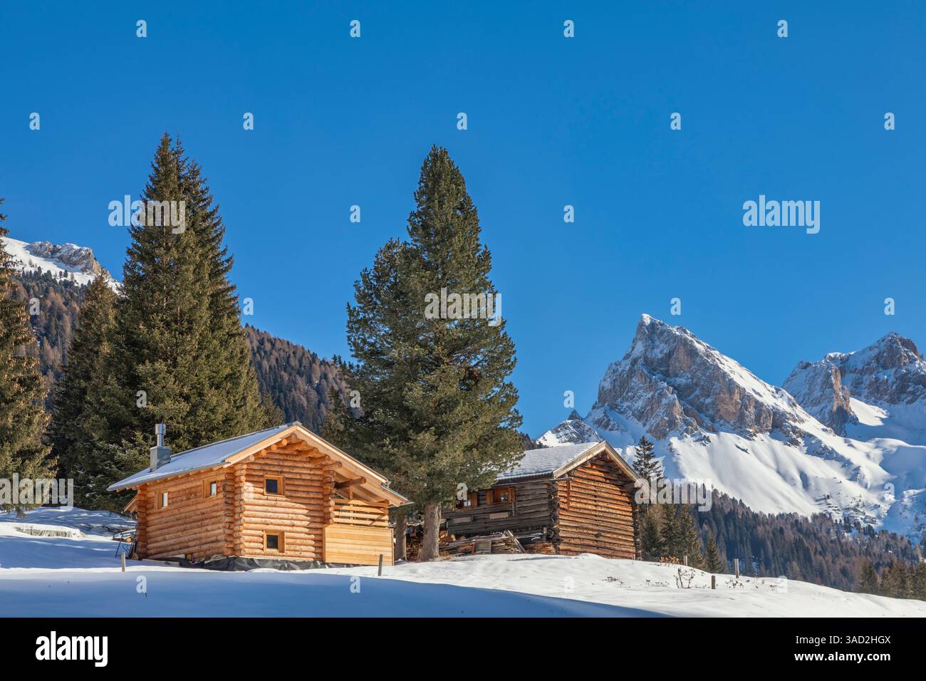 lonely huts in san nicolo valley, winter landscape on a sunny day with snow and blue sky, pozza di fassa, autonomous province of trento, dolomites, italy Stock Photo
