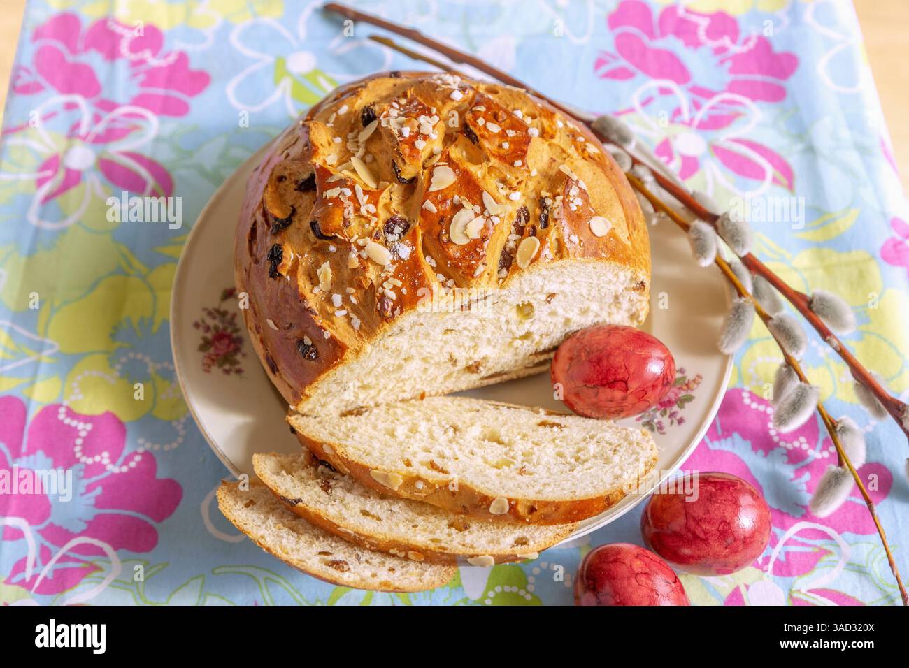 Easter cake with colorful Easter eggs on a plate and colorful tablecloth Stock Photo