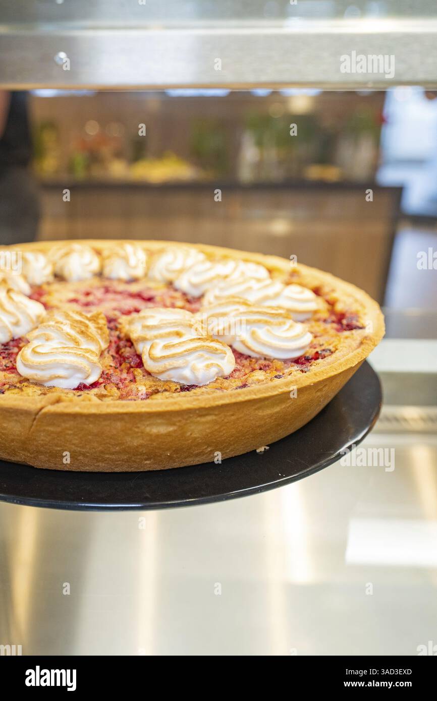 Cake with meringue topping and fruit filling in an illuminated glass display case, Cafe Kuh, Deckenpfronn, Germany, Europe Stock Photo