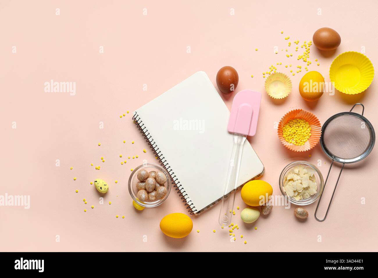 Blank notepad for recipes with Easter eggs and kitchen tools on beige background Stock Photo