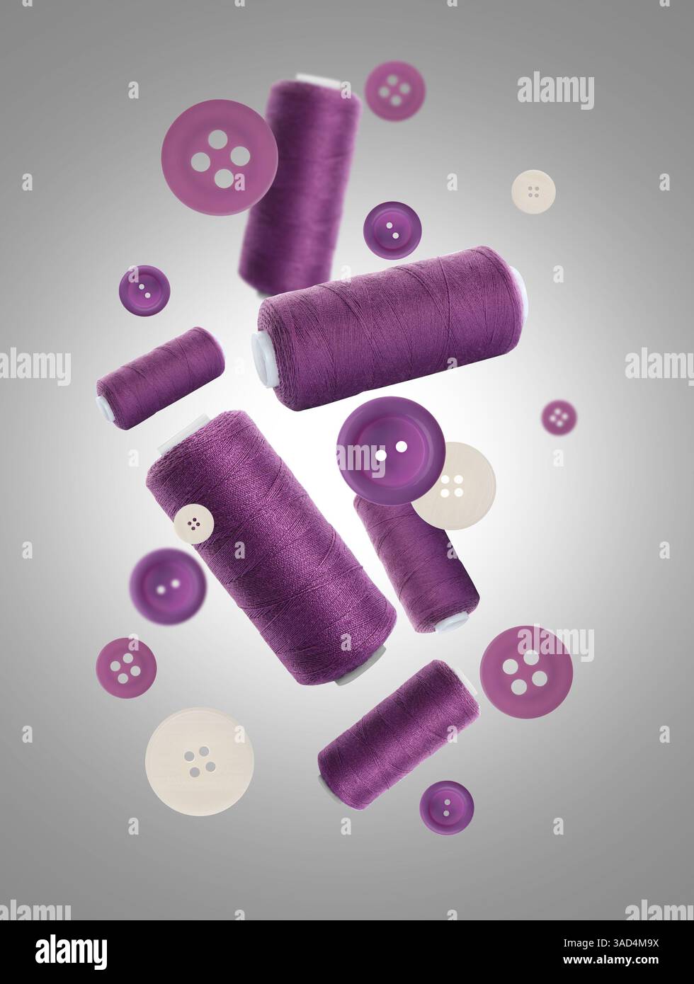 Many purple sewing threads and buttons falling on grey gradient background Stock Photo