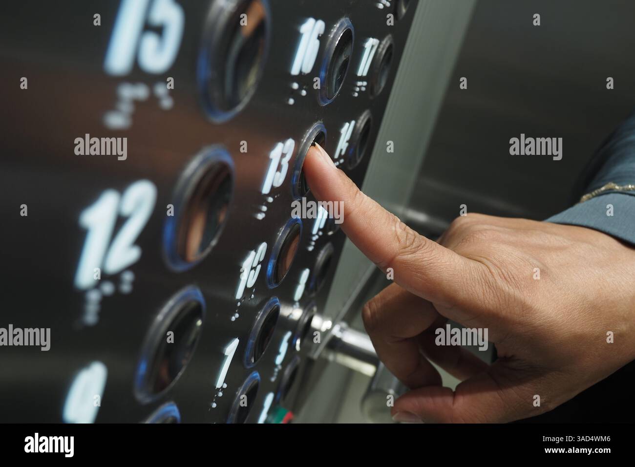 Close-up of a hand pressing elevator button on the floor panel Stock Photo