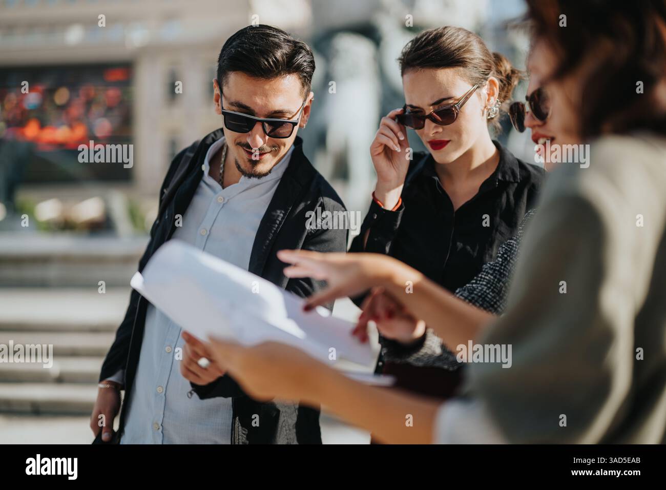 Group of business people reviewing documents outdoors Stock Photo - Alamy