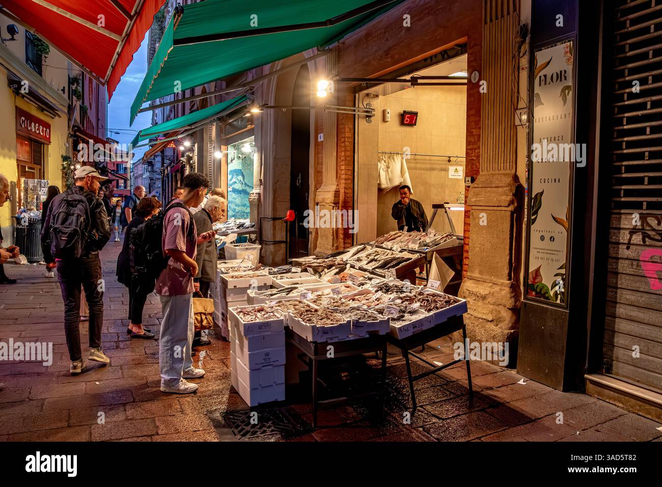 People looking at the resh fish on sale at a fish market stall on Via Drapperie in Bologna,Italy Stock Photo