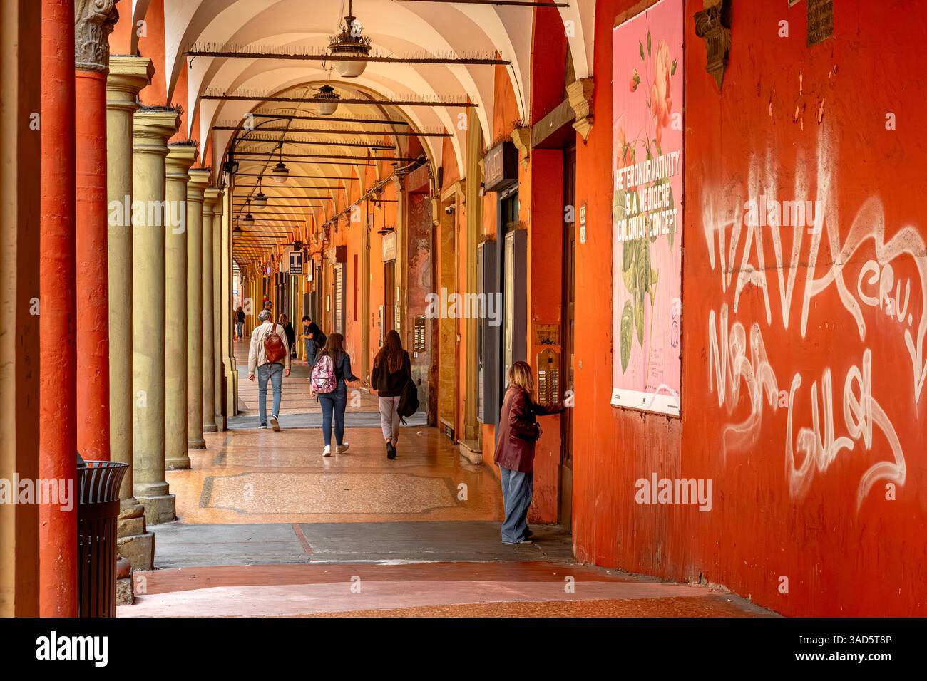 People walking along the portico on Via San Vitale in Bologna, Italy Stock Photo