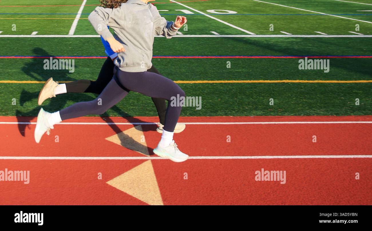 Two Athletes Sprinting Down A Running Track Synchronized Perfectly 