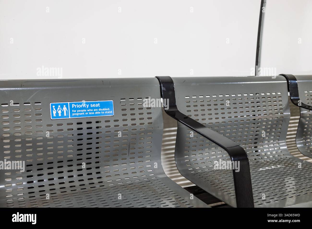 Priority seating sign on metallic bench in London Underground station Stock Photo
