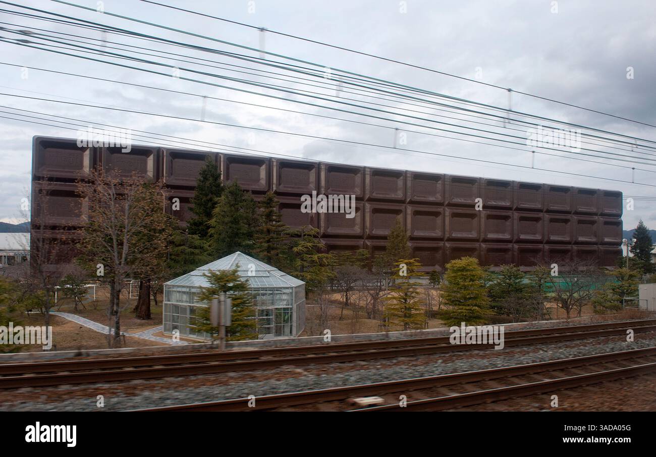 Giant chocolate bar seen from JR train line in Takatsuki near Osaka: the facade of Meiji chocolate factory leaving no doubt about their product, Japan Stock Photo