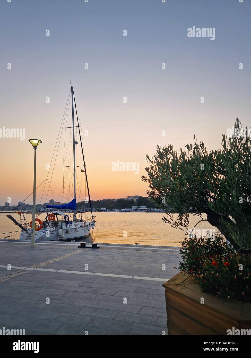 Sailboat docked at a pier during sunset. Serene maritime scene - Smartphone Captured Stock Image