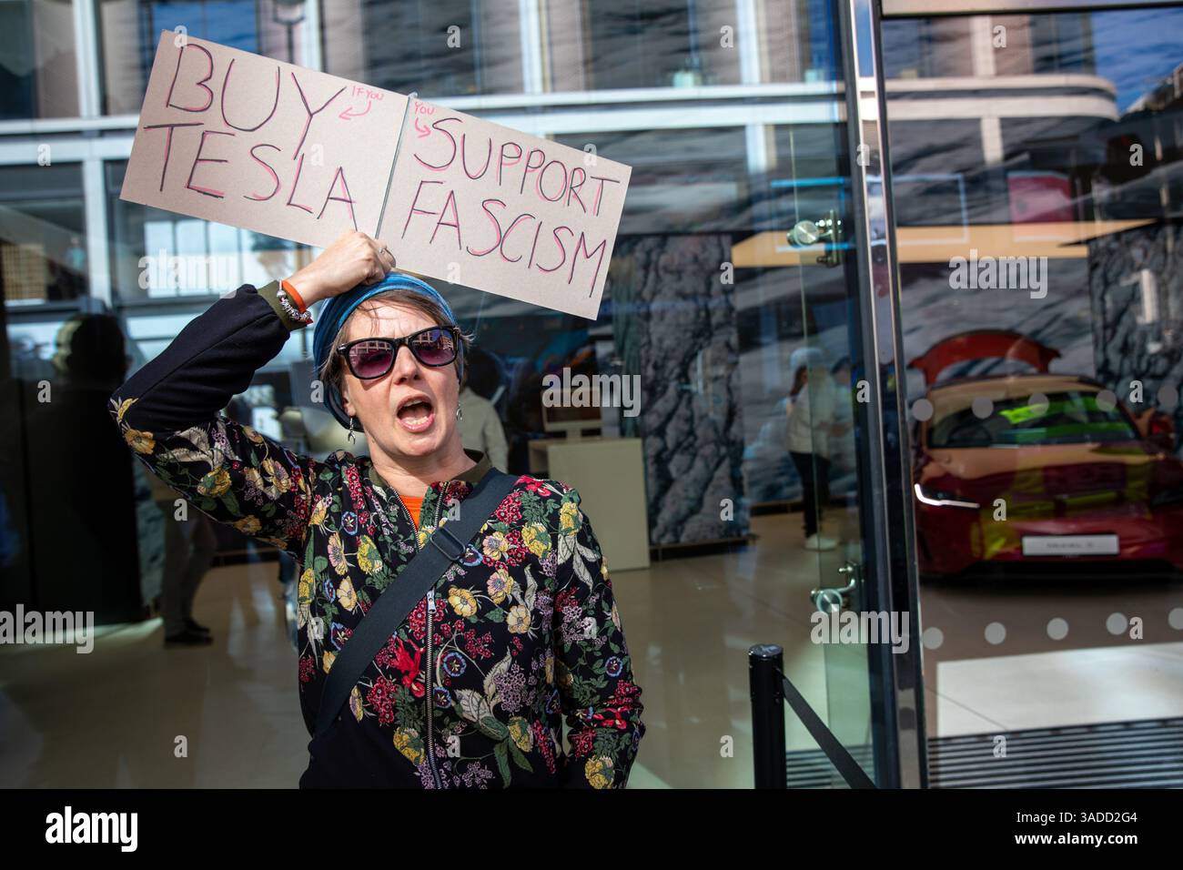 An activist holds a placard during an anti Tesla demonstration. A ...