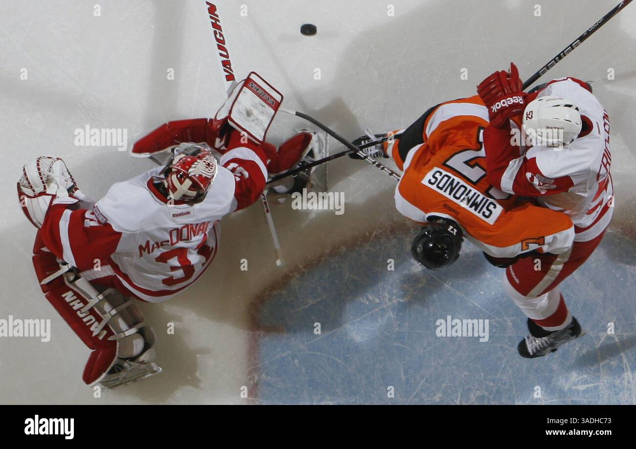Feb. 12, 2012 - Detroit, MI, USA - Detroit Red Wings Jonathan Ericsson ties up Philadelphia Flyers Wayne Simmonds as Wings goalie Joey MacDonald makes  a save in the first period in Detroit, Michigan, on Sunday, February 12, 2012. (Credit Image: © Julian H. Gonzalez/Detroit Free Press/MCT/ZUMAPRESS.com) Stock Photo