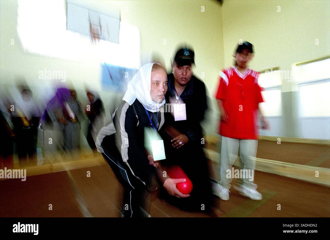 Aug 24, 2005; Kabul, AFGHANISTAN; A female athlete, wearing a white scarf, throwing a red ball, plays bocce at Bagh-e-Zanana. More than 300 athletes, including 80 female athletes, experienced a taste of happiness and achievement for the first time in their lives. They competed in athletics, bocce and football (soccer). Because of cultural restrictions, males and females competed at separate venues..  (Credit Image: Kash Gabriele Torsello/ZUMAPRESS.com) Stock Photo